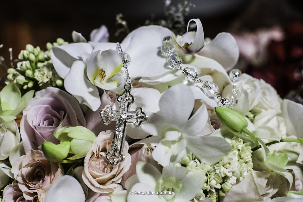 fotografo de casamento autoral fez fotografia autoral de casamento com buquet de noiva com flores orquideas e tambem um terço compondo um cenario lindo para casamento.