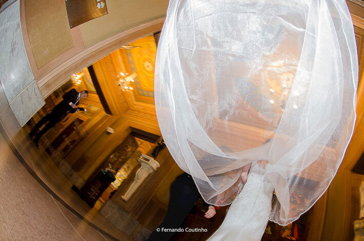 noiva com seu vestido de noiva e o veu esvoaçante na porta da igreja vestido de noiva feito pelo estilista de noivas donny archanjo na cidade de americana