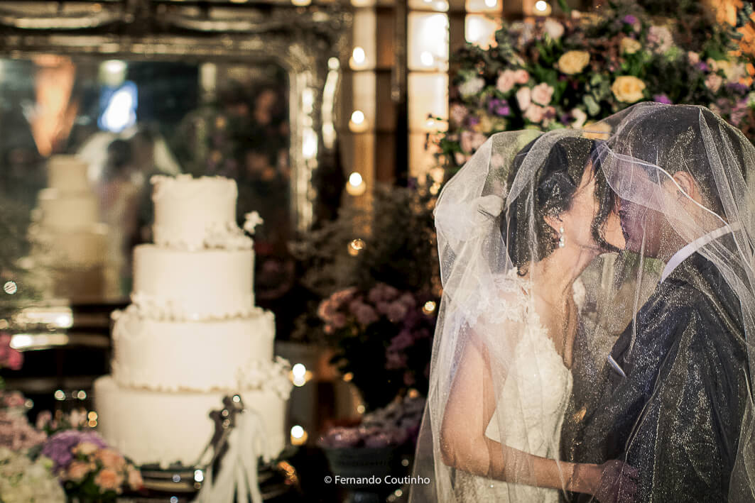 noivos se beijam a frente da mesa de bolo e de doces do casamento no espaco de festas e eventos villa sao vito na cidade de americana em fotografia de casamento feita pelo fotografo de casamento