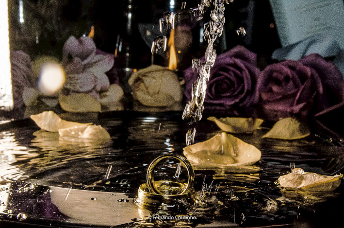 lida fotografia de casamento com detalhe das alianças do casamento com agua e raiso saindo da alianca dos noivos no salao de festas villa sao vito na cidade de americana sao paulo