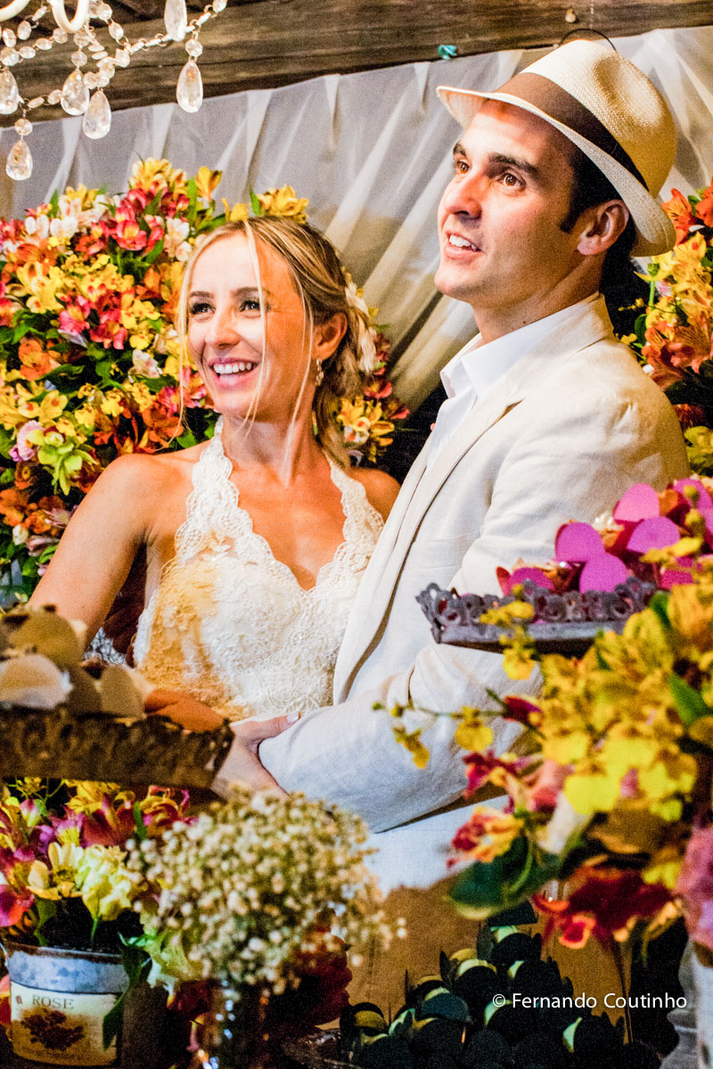 Corte do bolo, casal brindando, casal corta o bolo, noivos a mesa do bolo, mesa de doces, docinhos, tacinha do caamento, Entrada dos noivos, entrada do casal, entrada na festa, fotos noivo com chapeu, noivo com chapeu, , lua de mel,Casamento na praia, cas