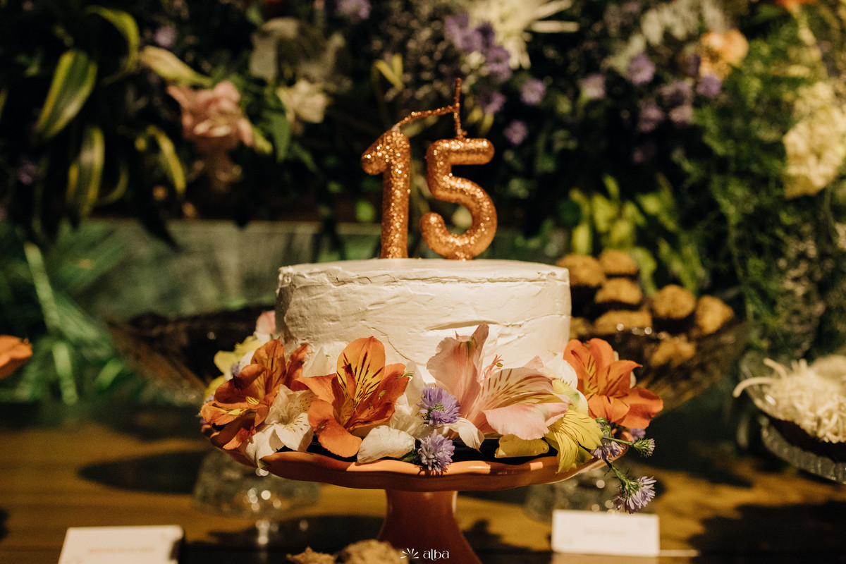Bolo decorado com flores e vela “15”, em festa de debutante da Julia no Roll, em Lajeado. Detalhe da mesa registrada pelo Alba Estúdio.