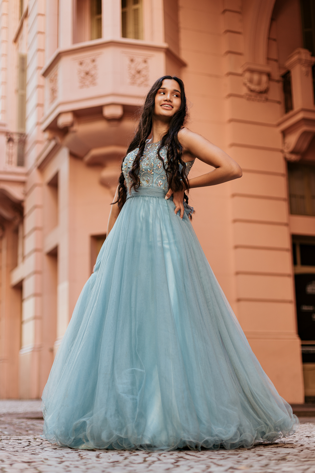 Djuly de vestido azul posando em frente à arquitetura clássica do Centro Histórico de Porto Alegre – foto por Alba Estúdio