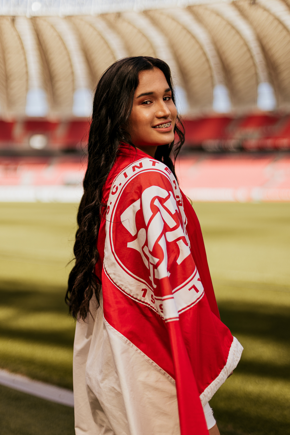 Close da debutante Djuly com bandeira do Internacional nos ombros, durante ensaio de 15 anos no Beira-Rio, em Porto Alegre – foto por Alba Estúdio.