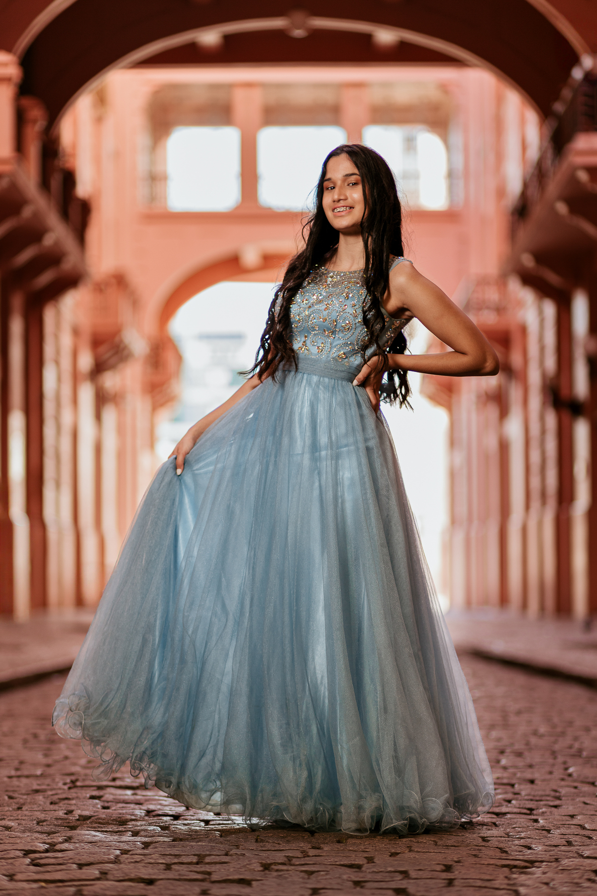 Djuly posando sob arco de prédio histórico no Centro Histórico de Porto Alegre – ensaio de 15 anos – foto por Alba Estúdio