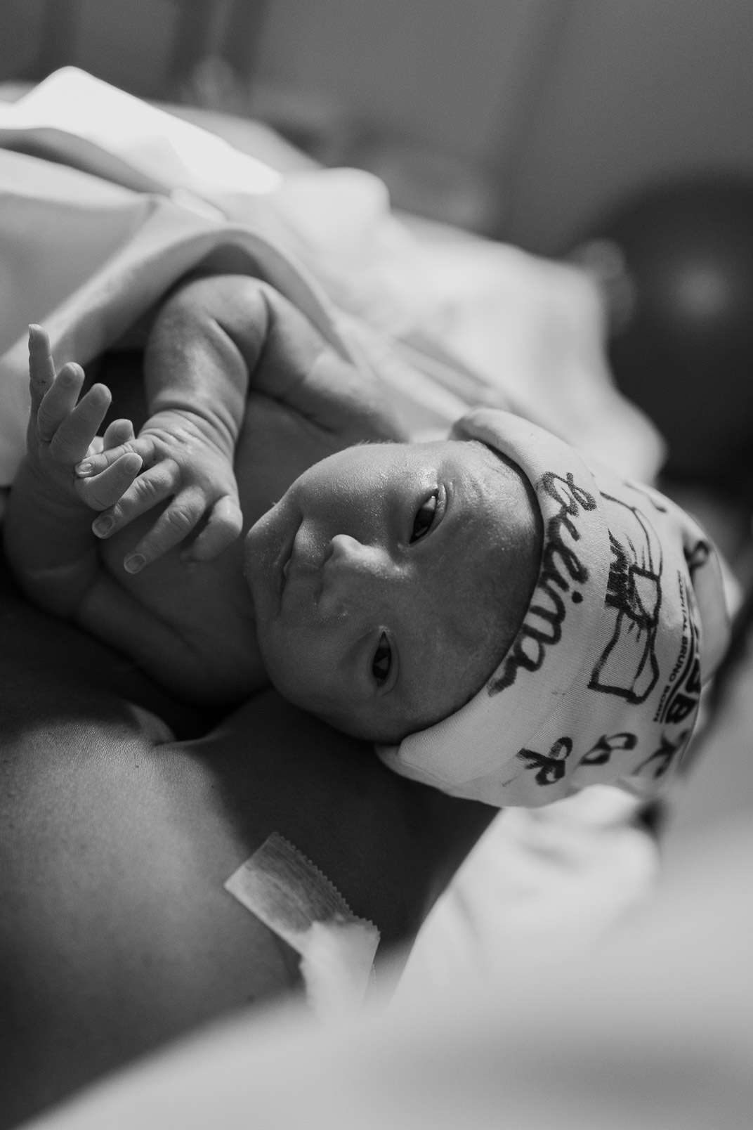Bebê nos braços da mãe, logo após o parto, com olhar atento e expressão tranquila – Hospital Bruno Born, Lajeado – Alba Estúdio