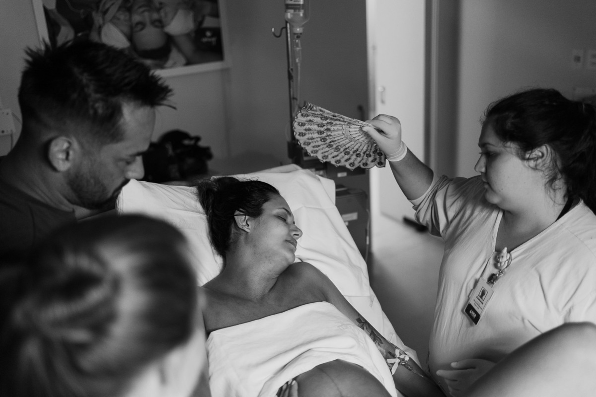 Mãe sendo abanada por profissional da saúde durante o parto no Hospital Bruno Born, em Lajeado — Alba Estúdio.