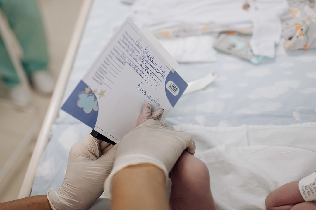 Pai segura seu filho recém-nascido nos corredores do Hospital Bruno Born em Lajeado — Foto por Alba Estúdio.