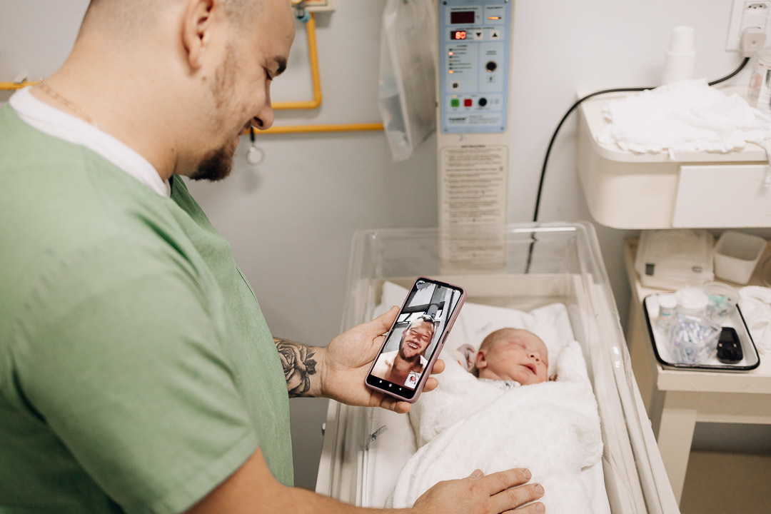 Pai apresenta o recém-nascido por videochamada direto do Hospital Bruno Born em Lajeado — Foto por Alba Estúdio.