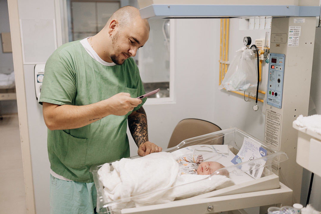 Pai apresenta o recém-nascido por videochamada direto do Hospital Bruno Born em Lajeado — Foto por Alba Estúdio.