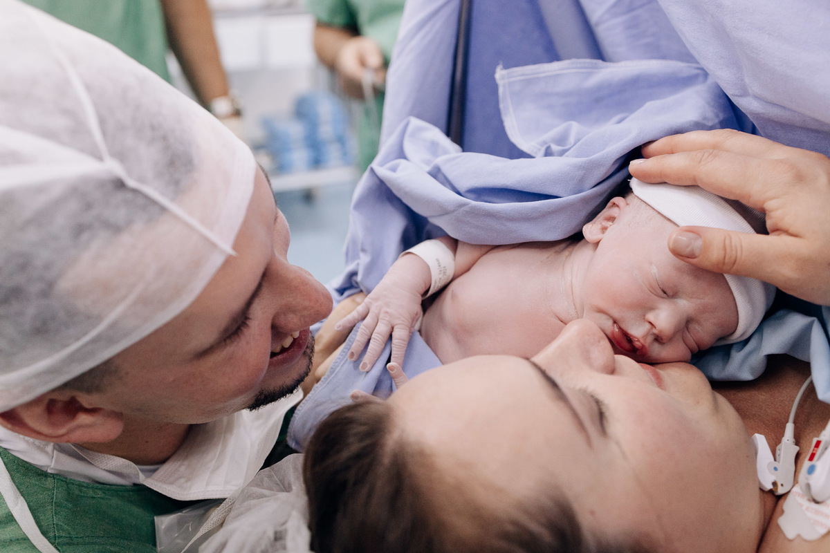 Bebê sendo acolhido nos braços da mãe e do pai logo após o nascimento no Hospital Bruno Born, Lajeado