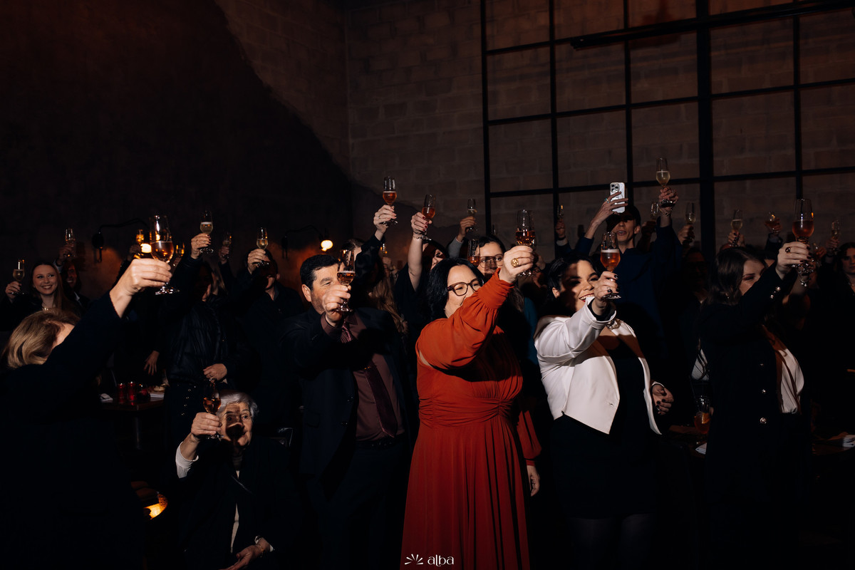 Convidados brindando com taças durante a formatura da Carolina no Bierdron.