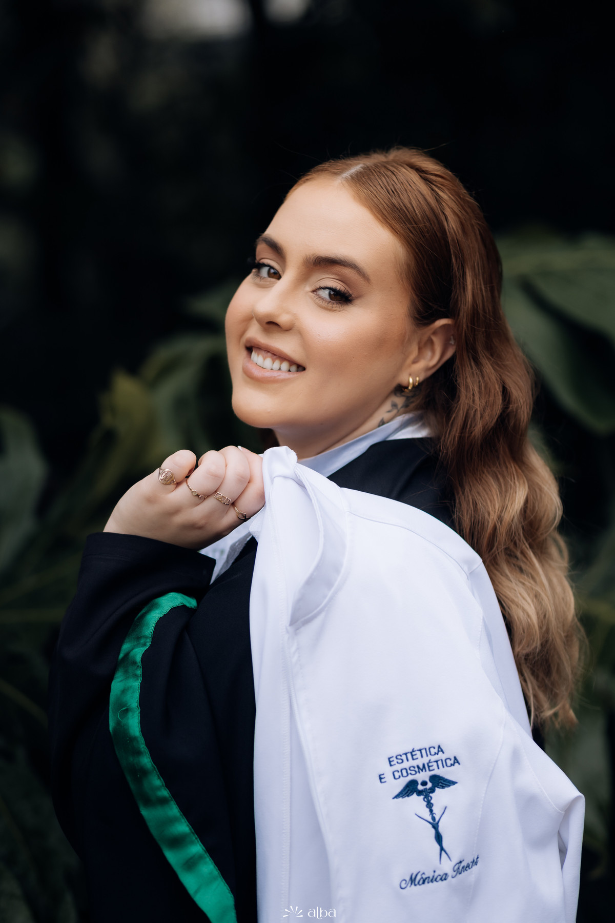 Formanda exibindo jaleco personalizado de Estética e Cosmética durante ensaio de prova de toga – Alba Estúdio, Lajeado.