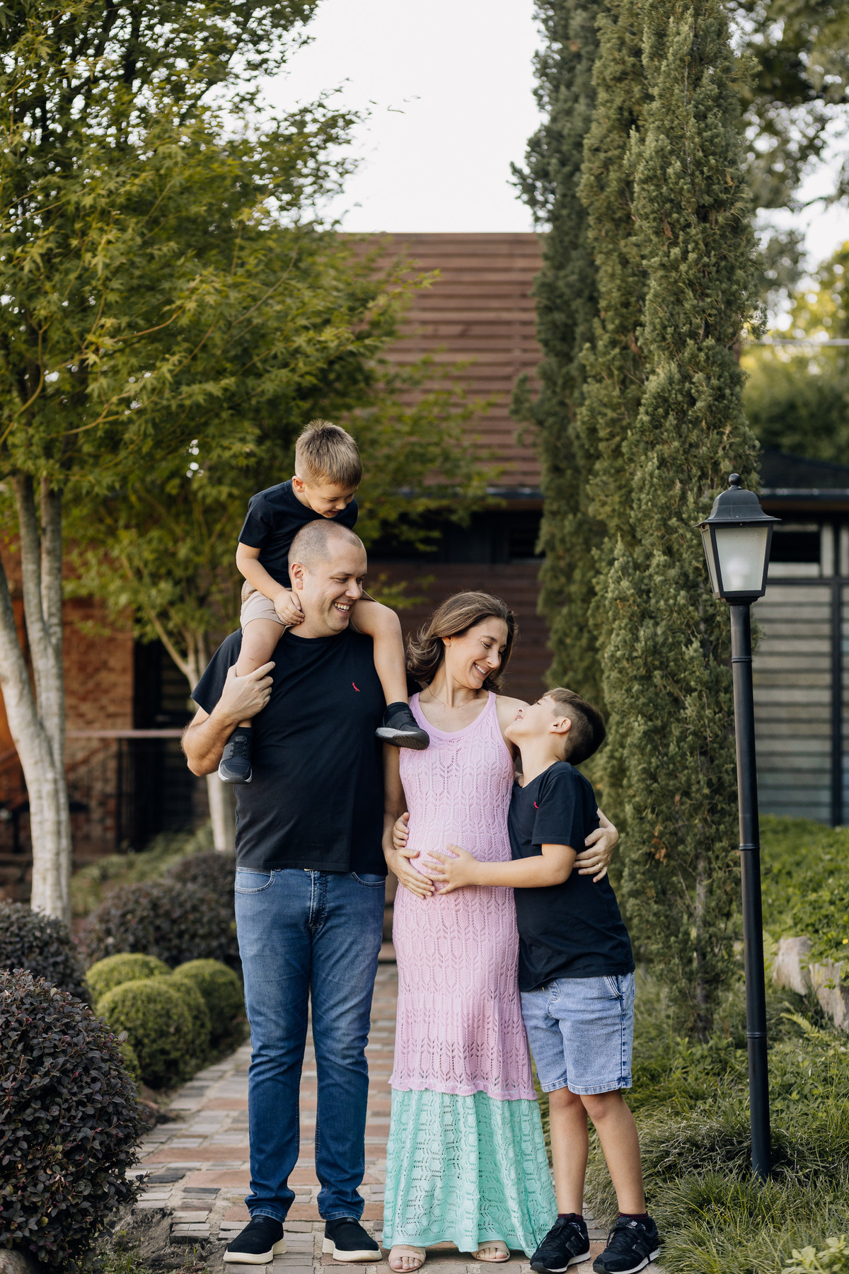 Família com dois filhos demonstrando carinho em ensaio gestante em área verde de Lajeado – fotografia por Alba Estúdio.