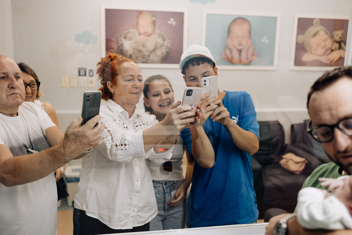 Família registrando a Amália com celulares no Hospital Bruno Born, em Lajeado/RS — foto do Alba Estúdio.
