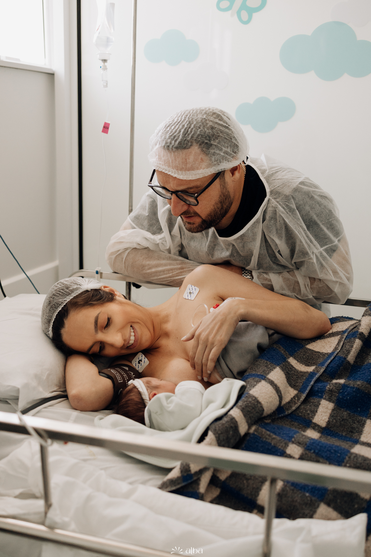 Amamentação e carinho: papai ao lado da mamãe com a Amália no colo no Hospital Bruno Born, em Lajeado/RS — Alba Estúdio.