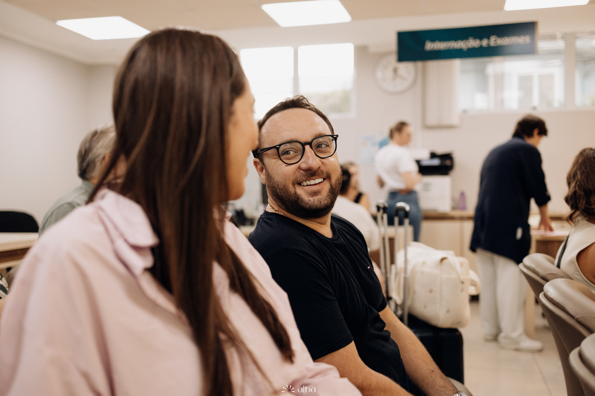 Pai sorrindo na sala de espera do Hospital Bruno Born, em Lajeado/RS, antes do nascimento da Amália. Foto feita pelo Alba Estúdio.