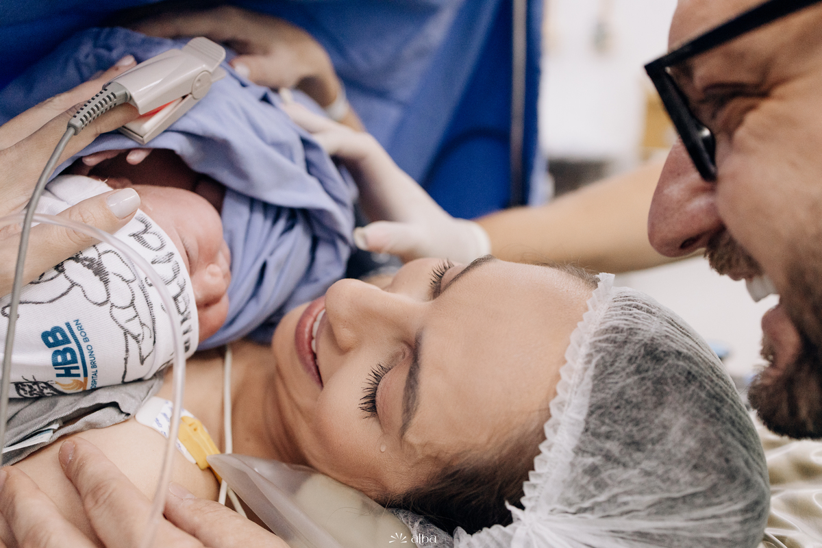 Mãe sorri ao ver a Amália no primeiro contato após o nascimento no Hospital Bruno Born, em Lajeado/RS — foto feita pelo Alba Estúdio.