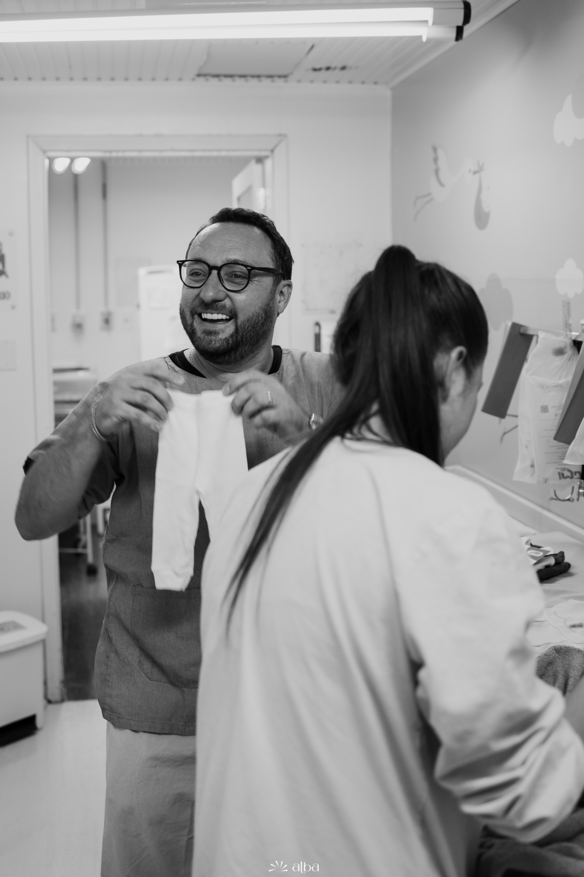 Bastidores do nascimento: pai prepara a primeira roupinha da Amália no Hospital Bruno Born, em Lajeado/RS — foto feita pelo Alba Estúdio.