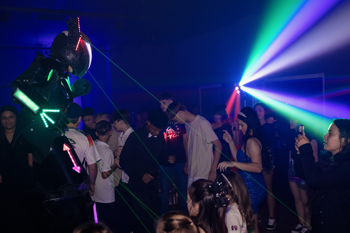 Robô de LED e lasers animando a pista no aniversário de 15 anos da Manu na Villa Bosco, Lajeado/RS — registro do Alba Estúdio.