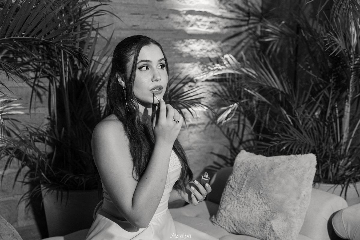 Ana Pellini retocando a maquiagem em foto preto e branco durante sua festa de formatura na Casa Irmando, pelo Alba Estúdio.