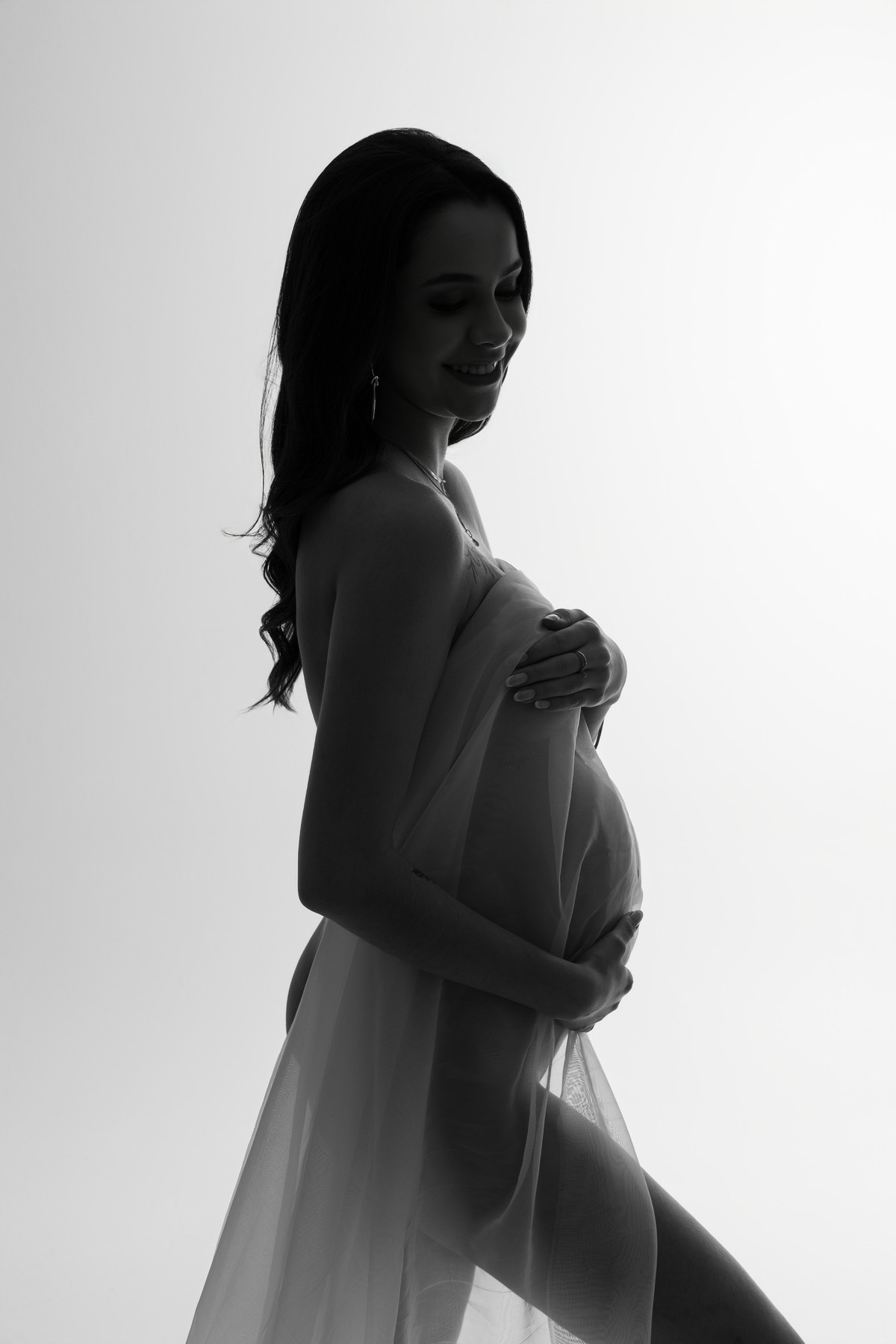 Retrato artístico de gestante de perfil, com luz lateral e composição minimalista que evidencia a beleza da maternidade. Alba Estúdio Fotográfico, Lajeado, RS.