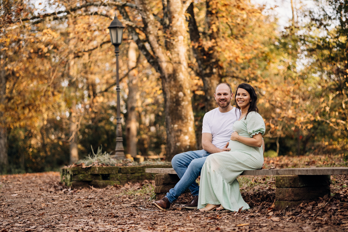 Casal aguardando a chegada do bebê em retrato realizado em parque com cenário de outono | Alba Estúdio, Lajeado RS.