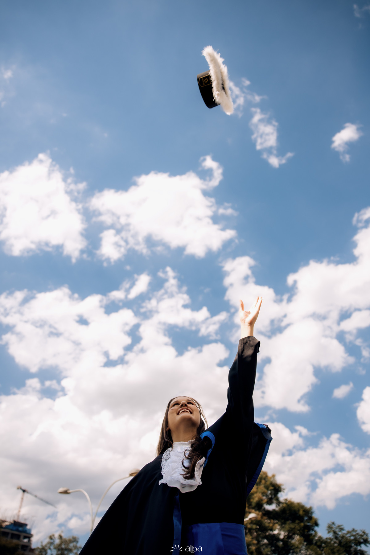 Formanda lançando o capelo ao céu em comemoração durante ensaio de formatura na Univates | Alba Estúdio, Lajeado RS.