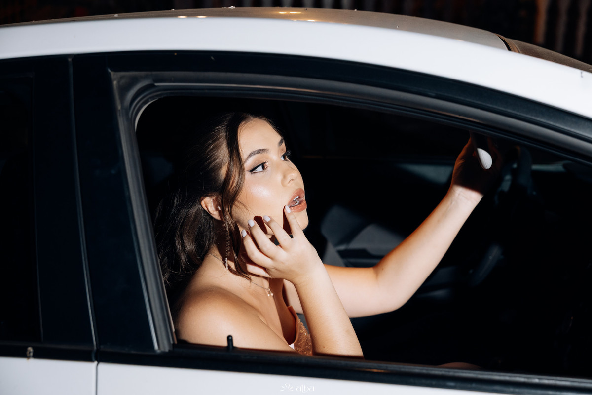 Ana Pellini retocando a maquiagem dentro do carro antes de chegar à festa de formatura na Casa Irmando.
