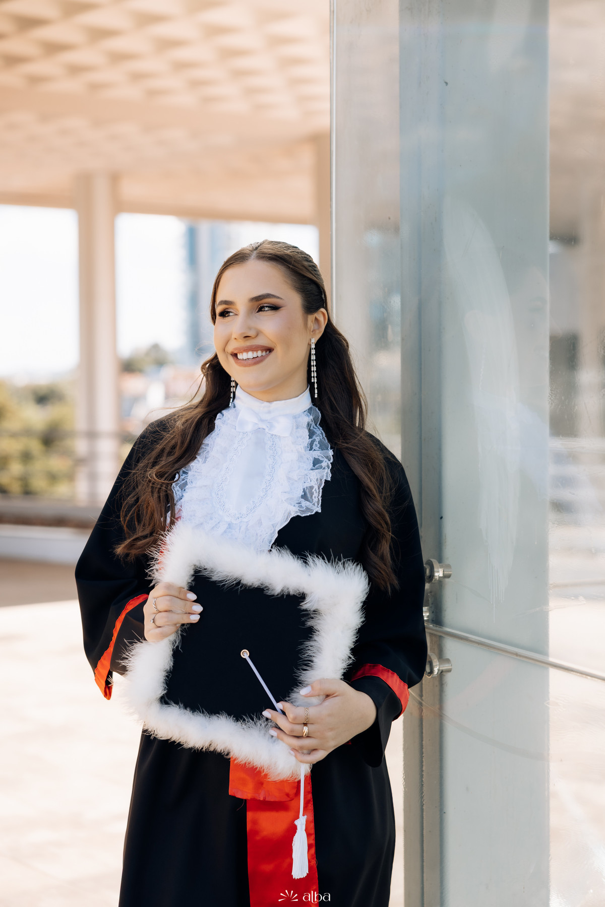 Retrato de Ana Pellini com toga e capelo durante ensaio de formatura no campus da Univates | Alba Estúdio, Lajeado RS.