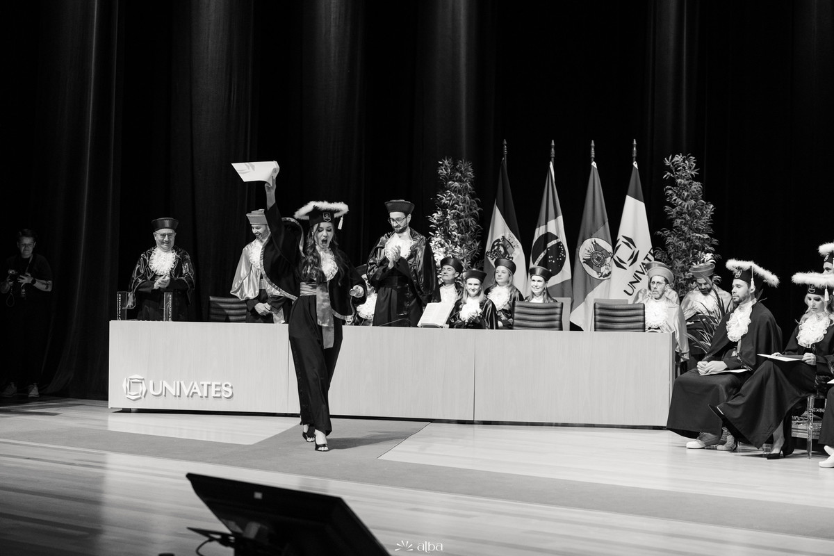 Ana Pellini celebrando a conquista no palco durante a colação de grau da Univates | Cobertura de formatura pelo Alba Estúdio.
