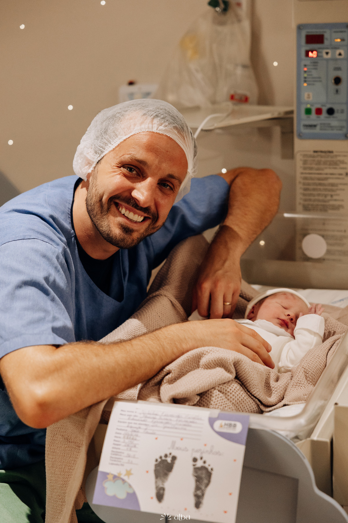 Pai emocionado ao lado do bebê recém-nascido no berçário do Hospital Bruno Born, em Lajeado. Registro dos primeiros momentos por Alba Estúdio.