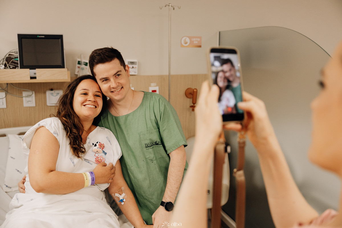 Casal posa antes do nascimento enquanto é fotografado no quarto do Hospital Bruno Born, em Lajeado. Cobertura de parto por Alba Estúdio.