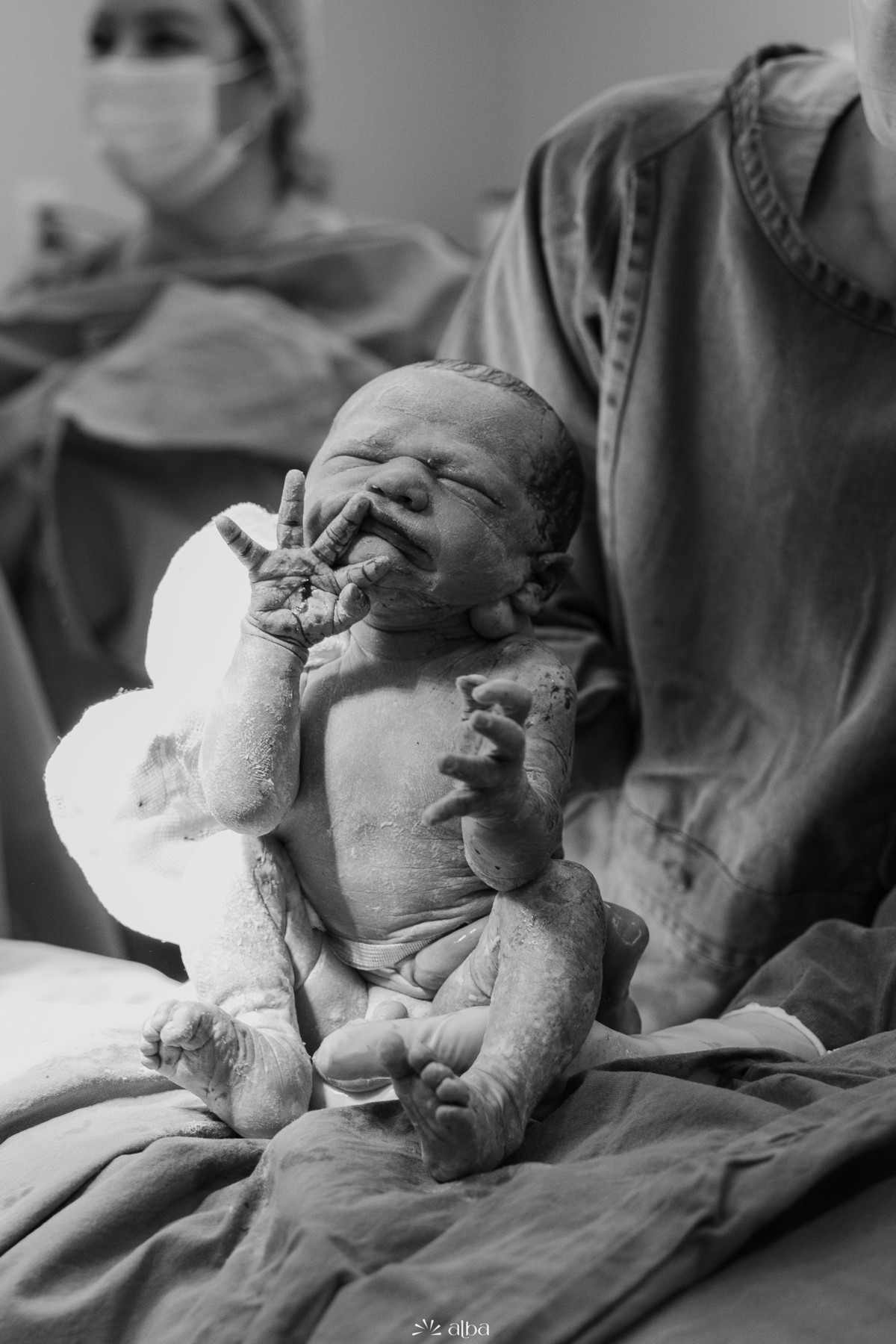Recém-nascido fotografado nos primeiros minutos de vida após o parto no Hospital Bruno Born, em Lajeado. Registro em preto e branco por Alba Estúdio.