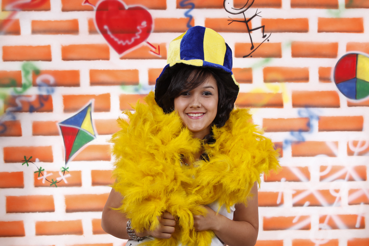 com um fundo fotografico colorido e alguns aderessos a modelo se destaca pelo sorriso e carinho com o fotografo nico. conheca o estudio do fotografo localizado na octogonal.