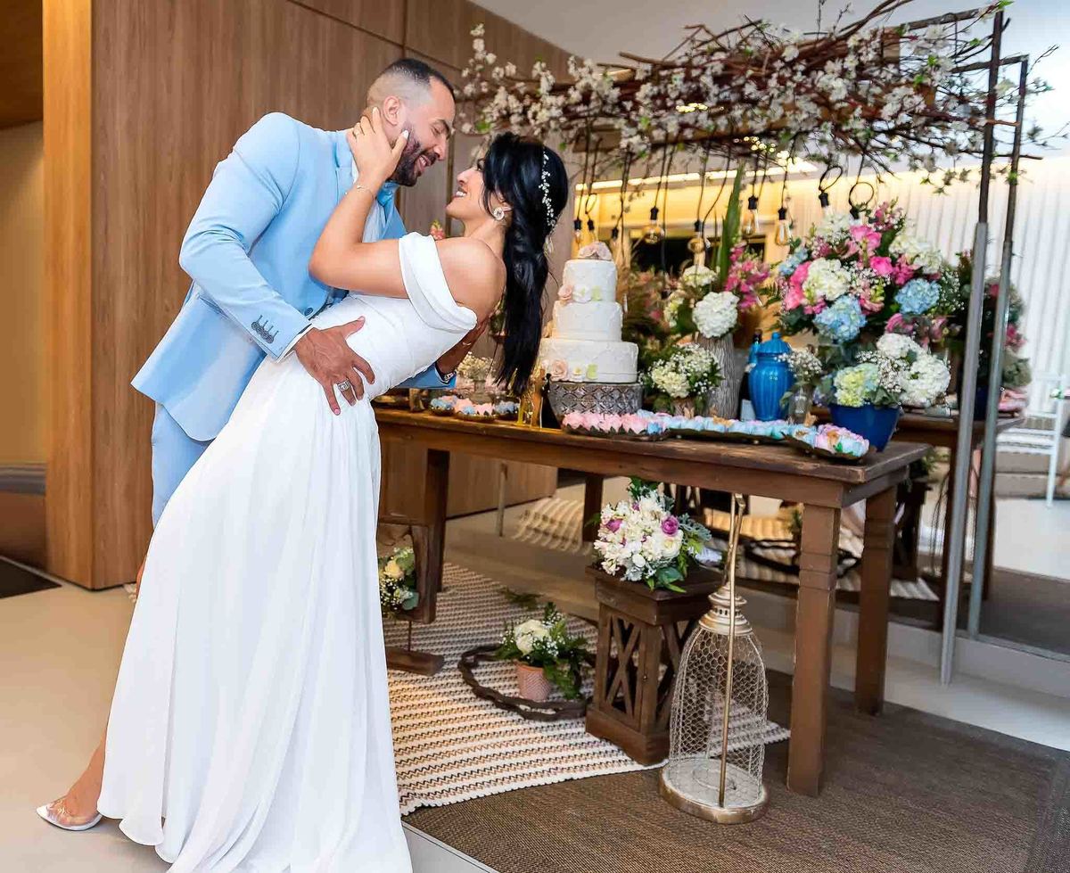 Cerimônia do casamento com a Débora e o Felipe se olhando com o vestido todo arrumado mostrando a mesa decorada do bolo casamento no Brás, São Paulo