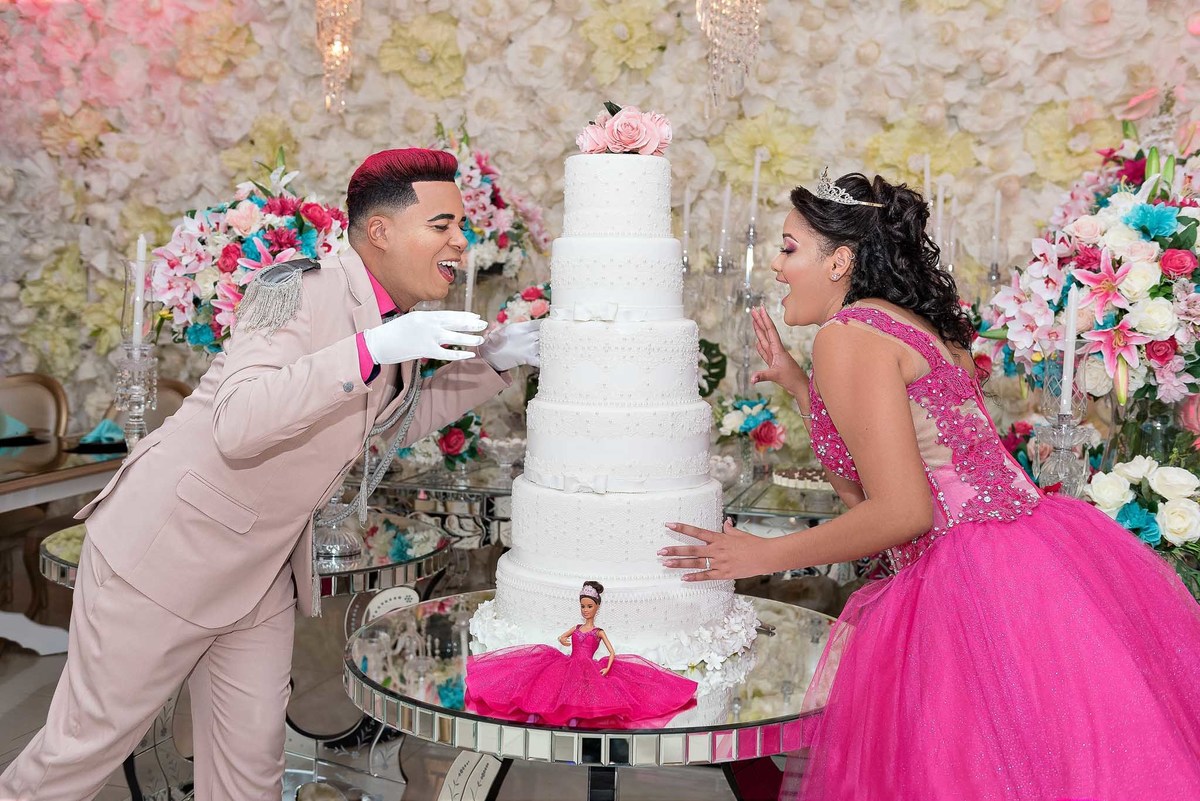 Príncipe da debutante brincando com a Jamile a cortar o bolo de debutante de vários andares, um momento tradicional da festa