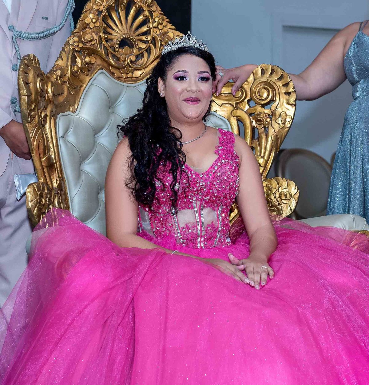 Um dançarino ou animador da festa, vestido com um terno claro e chapéu, levantando os braços no ar, animando os convidados em um palco