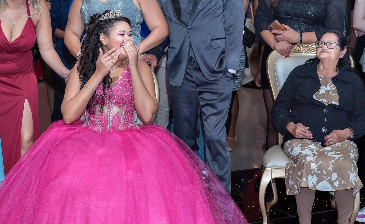 Jamile assistindo a retrospectiva acompanhada dos pais, avós e convidados