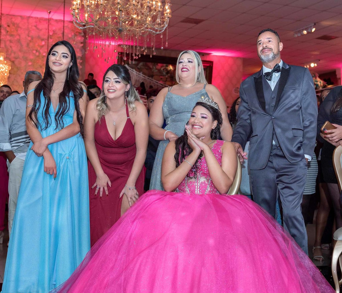 Jamile assistindo a retrospectiva acompanhada dos pais e irmãs