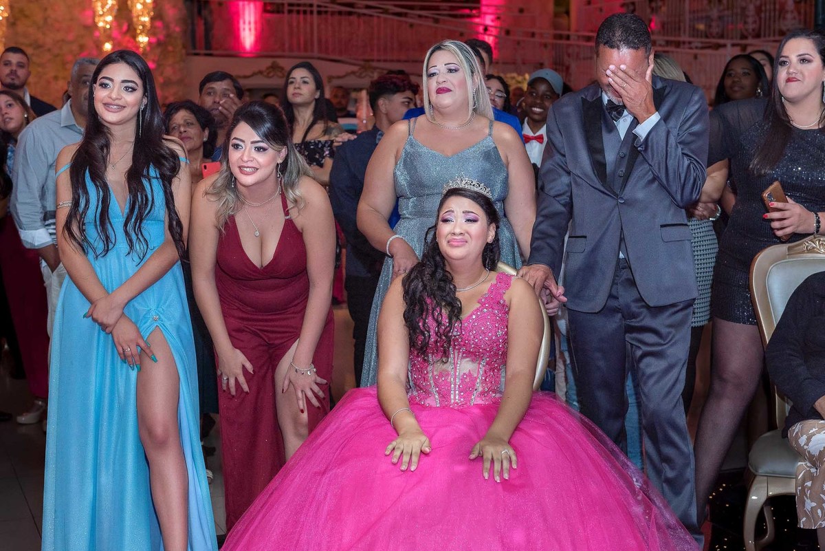 Jamile assistindo a retrospectiva acompanhada dos pais e irmãs e pai chorando