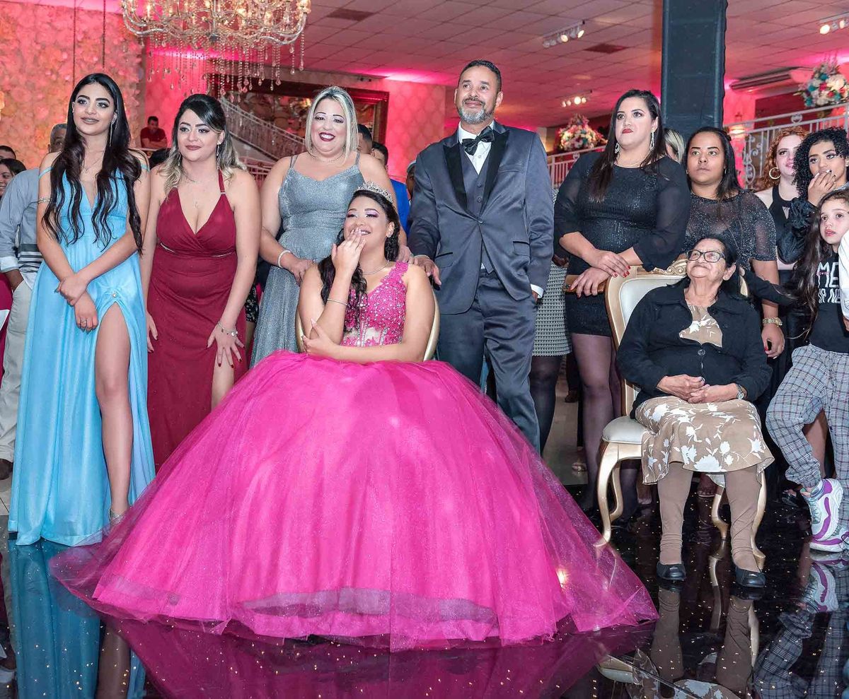 Jamile assistindo a retrospectiva acompanhada dos pais e irmãs e pai emocionado