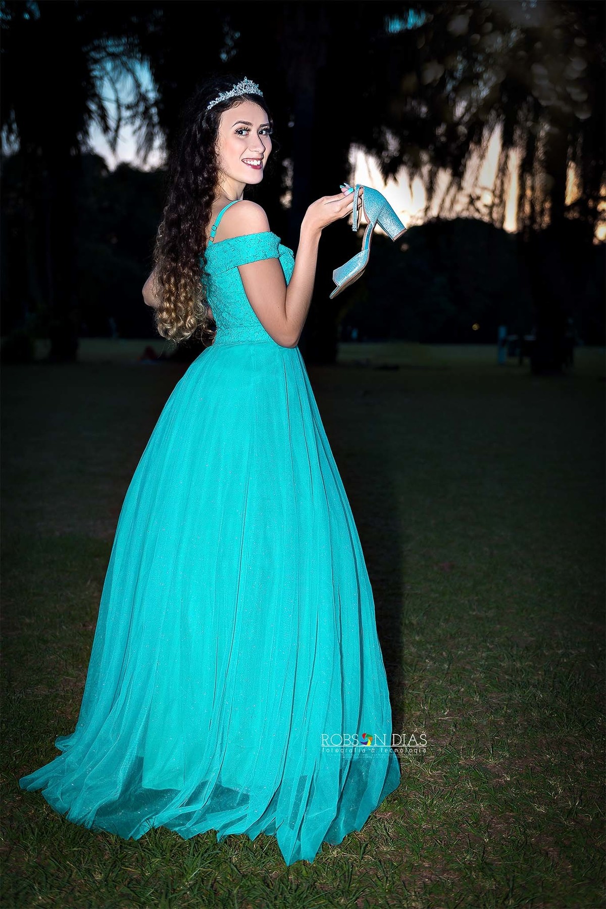 Brunna debutante segurando o sapato e em pé no ensaio de 15 anos no Parque do Ibirapuera, São Paulo.