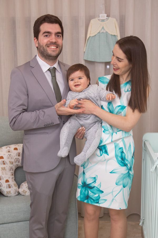 A Leonor a sorrir ao colo dos pais