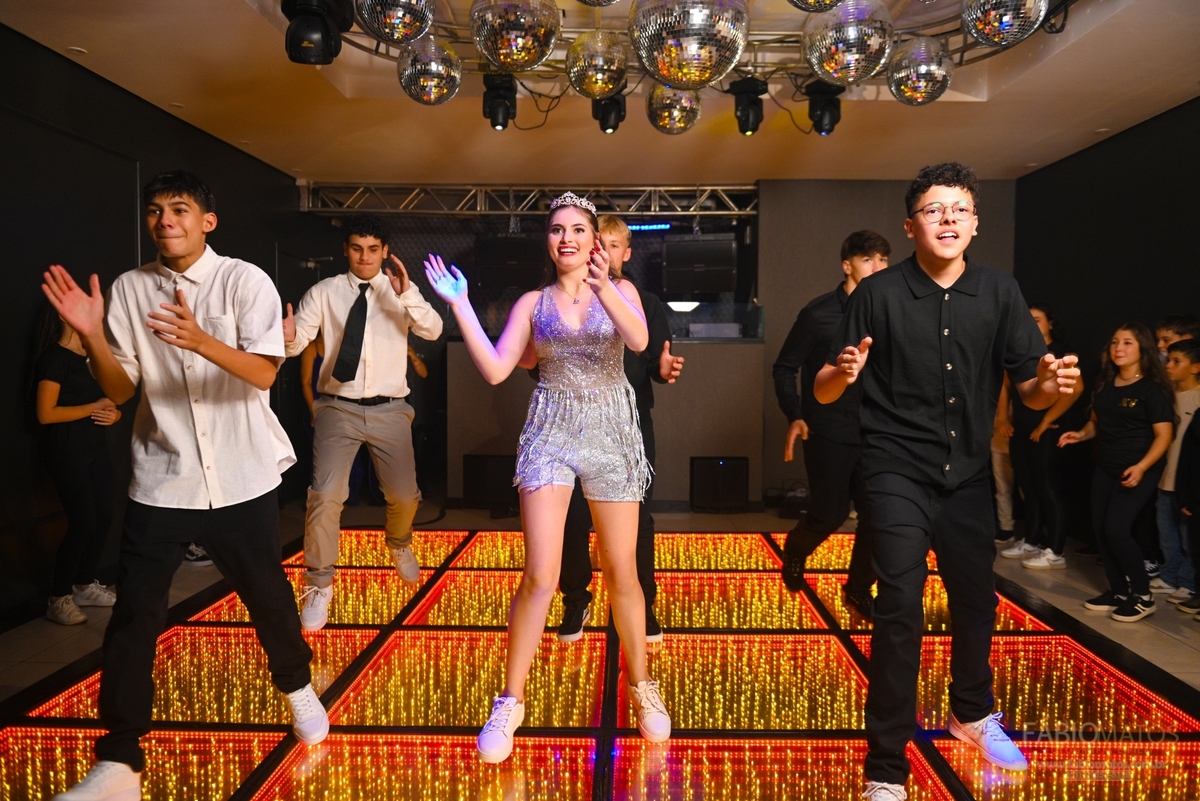 Pista de dança animada na festa de 15 anos, registrando a energia, a alegria e a celebração dos convidados durante a noite.