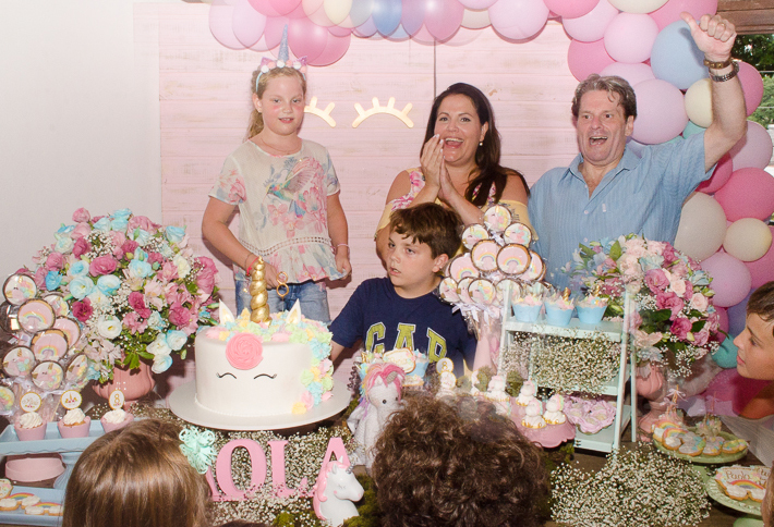 foto na hora do parabéns da Paola com pais e irmão 