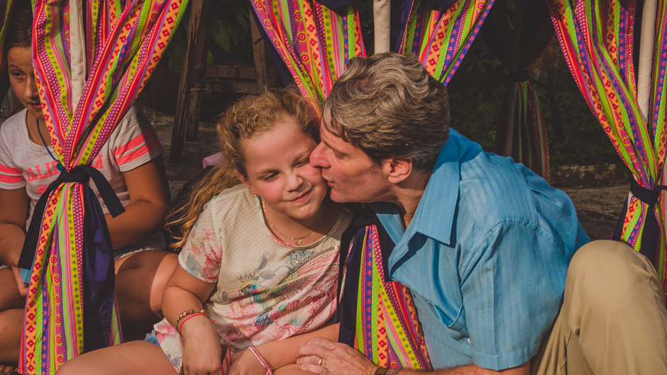 pai dando beijo carinhoso em filha