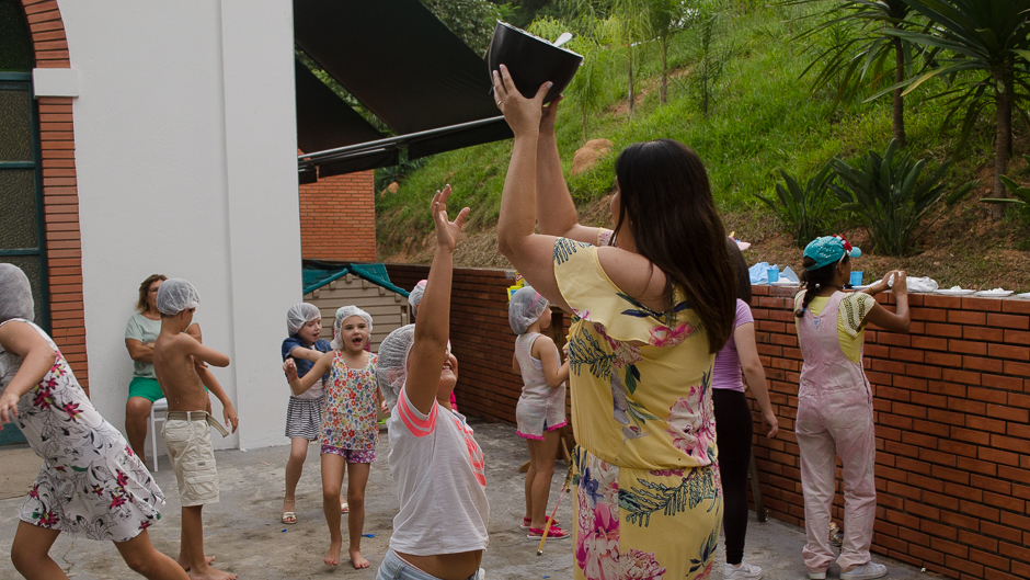 mãe da aniversariante com chantili em  mãos 
