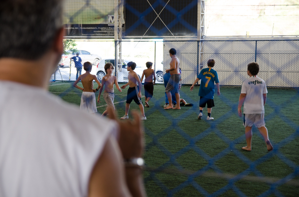 pai olhando filho jogar futebol