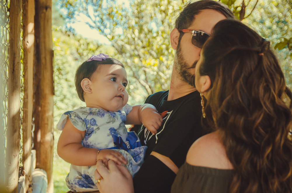papai e mamae se beijando com filha nos braços 